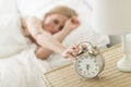 Woman Pressing Button Of Alarm Clock On Night Table Royalty Free Stock Photo