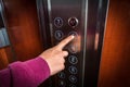 Woman pressing the button in the elevator interior