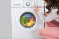 Woman Pressing Button Of Washing Machine