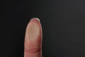 Woman pressing control glass of biometric fingerprint scanner on dark background, closeup.