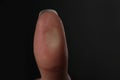 Woman pressing control glass of biometric fingerprint scanner on dark background