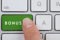 Woman pressing green Bonus button on keyboard, closeup