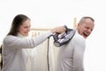 Woman pressing a man with an iron wrinkles prank mockery family feelings how to refresh emotions in family upbringing by