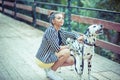 Woman pretty girl on the bridge holding her dog who is barking to strangers