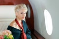 Woman private plane in a jacket with a red tie, New Year& x27;s Eve flight, holiday and travel