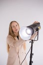 Woman Professional gaffer adjusts constant light