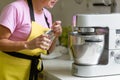 Woman professional pastry chef preparing a dessert. Adds ingredients and mixes the dough in a mixer