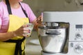 Woman professional pastry chef preparing a dessert. Adds ingredients and mixes the dough in a mixer