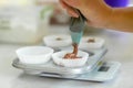 Woman professional pastry chef spreads chocolate dough in baking dish