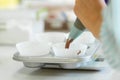 Woman professional pastry chef spreads chocolate dough in baking dish