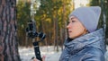 Professional Videographer Holding DSLR Camera on 3-axis Gimbal Stabilization Device in Winter. Cinematographer Operator