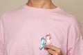 Woman promoting breast cancer awareness with pink and blue ribbon for men and women