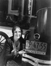 Woman with prosperity sign on car bumper