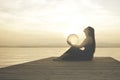 Woman protecting a magical sphere illuminated by the sun that releases energy and inner strength, abstract concept Royalty Free Stock Photo