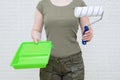 Woman in protective clothing with a paint roller and cuvette in her hands. Painting the walls of the room Royalty Free Stock Photo