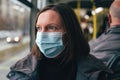 Woman with protective face mask riding public transportation bus in winter Royalty Free Stock Photo