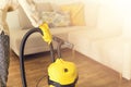 Woman in protective gloves cleaning the living room with yellow vacuum cleaner. Copy space. Clean concept Royalty Free Stock Photo