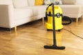 Woman in protective gloves cleaning the living room with yellow vacuum cleaner. Copy space. Clean concept Royalty Free Stock Photo