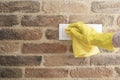 Woman in protective gloves disinfecting wall switches while cleaning at home, close-up view on hands Royalty Free Stock Photo