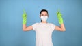 Woman in protective gloves and face mask, pointing up. Commercial cleaning company concept. Royalty Free Stock Photo