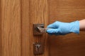 Woman in protective gloves opening door, closeup Royalty Free Stock Photo