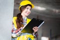 Woman in a protective helmet and a reflective vest conducts an inspection at a construction site Royalty Free Stock Photo