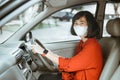 Woman in protective mask driving a car on road. Safe traveling. Royalty Free Stock Photo