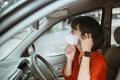 Woman in protective mask driving a car on road. Safe traveling. Royalty Free Stock Photo