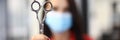 Woman in protective mask hold scissors in hand closeup. Royalty Free Stock Photo