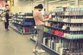 Woman in protective mask at the mall. Alarmed female wears medical mask against coronavirus while grocery shopping in supermarket