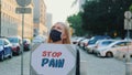 Woman in protective mask protesting to stop pain by holding steamer