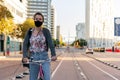 Woman with protective mask riding bicycle at city