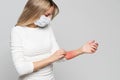 Woman in protective mask scratching her arm, isolated. Symptoms of animal allergy, itchy skin