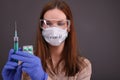 Woman in protective mask with sign `covid-19` looks on pills