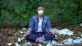 Woman protective mask sitting lotus pose garbage landfill, health danger, poison