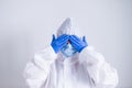 A woman in a protective suit and a medical mask covers her eyes with her hands. I do not see evil Royalty Free Stock Photo