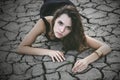 Woman protects a small sprout on a cracked desert soil