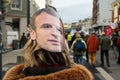 Woman protesting in the street against the global security law with an E macron the french president potrait on head