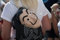 Woman protesting in the street with a dali mask on her back