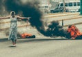 Woman protesting in Venezuela, burning tires,