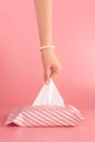 Woman pull the tissue paper out of the tissue box isolated on pink background, vertical. sanitation and hygiene facility concept.