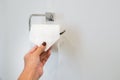 Woman pull tissue from roll in toilet for cleaning Royalty Free Stock Photo