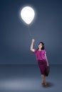 Woman pulling a bright balloon