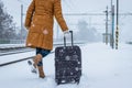 Woman pulling heavy luggage at a snow railroad station Royalty Free Stock Photo