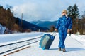 Woman pulling heavy luggage at a snow train station. Travelling by train at winter. Royalty Free Stock Photo