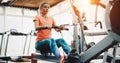 Woman pulling on row machine in fitness Royalty Free Stock Photo