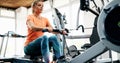 Woman pulling on row machine in fitness Royalty Free Stock Photo