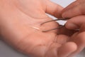 Woman pulling splinter from finger using tweezers on white background, closeup Royalty Free Stock Photo