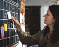 Woman pulling sticky note from calendar plan on wall Royalty Free Stock Photo