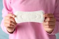 Woman in pullover holding sanitary pad